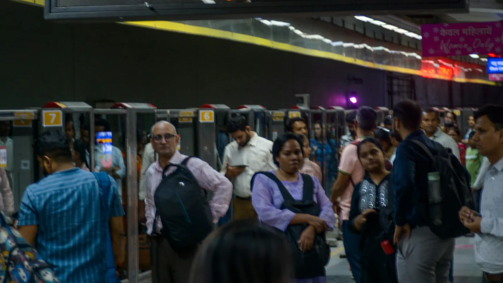 Passengers moving through a busy Delhi Metro station